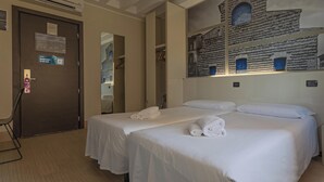 A hotel room with two beds, a large wall mural, a door with a keycard reader, and a mirror. - Hotiday Firenze Guidoni (Florence)