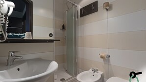 Une salle de bain équipée d’un lavabo, d’un bidet, de toilettes et d’une douche à parois de verre.