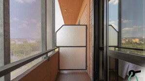 A narrow balcony with a view of the cityscape, a sliding door, and a mesh screen. - Hotiday Firenze Guidoni (Florence)