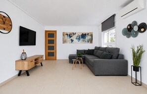 A modern living room with a grey sofa, wooden sideboard, and a flat-screen TV. - SUN, SAND & LUXURY SEAFRONT APARTMENT VERACRUZ LEVANTE (R154) (Benidorm)