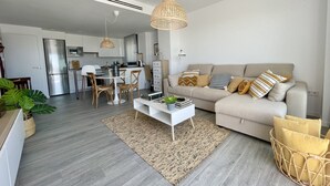 Una sala de estar moderna con sofá, mesa de centro y zona de comedor.