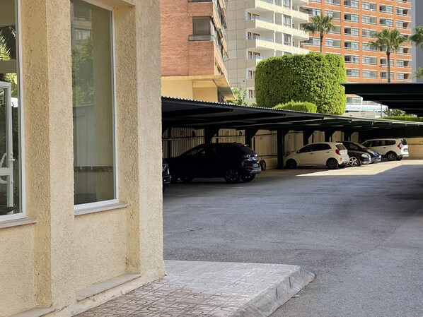 A parking area with multiple cars, a covered structure, and a building with balconies in the background. - MONVER LEVANTE BEACH N069 (Benidorm)