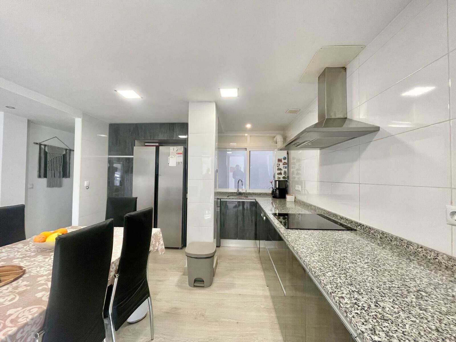 Cozinha moderna com bancada de granito, eletrodomésticos de aço inoxidável e uma ilha central.