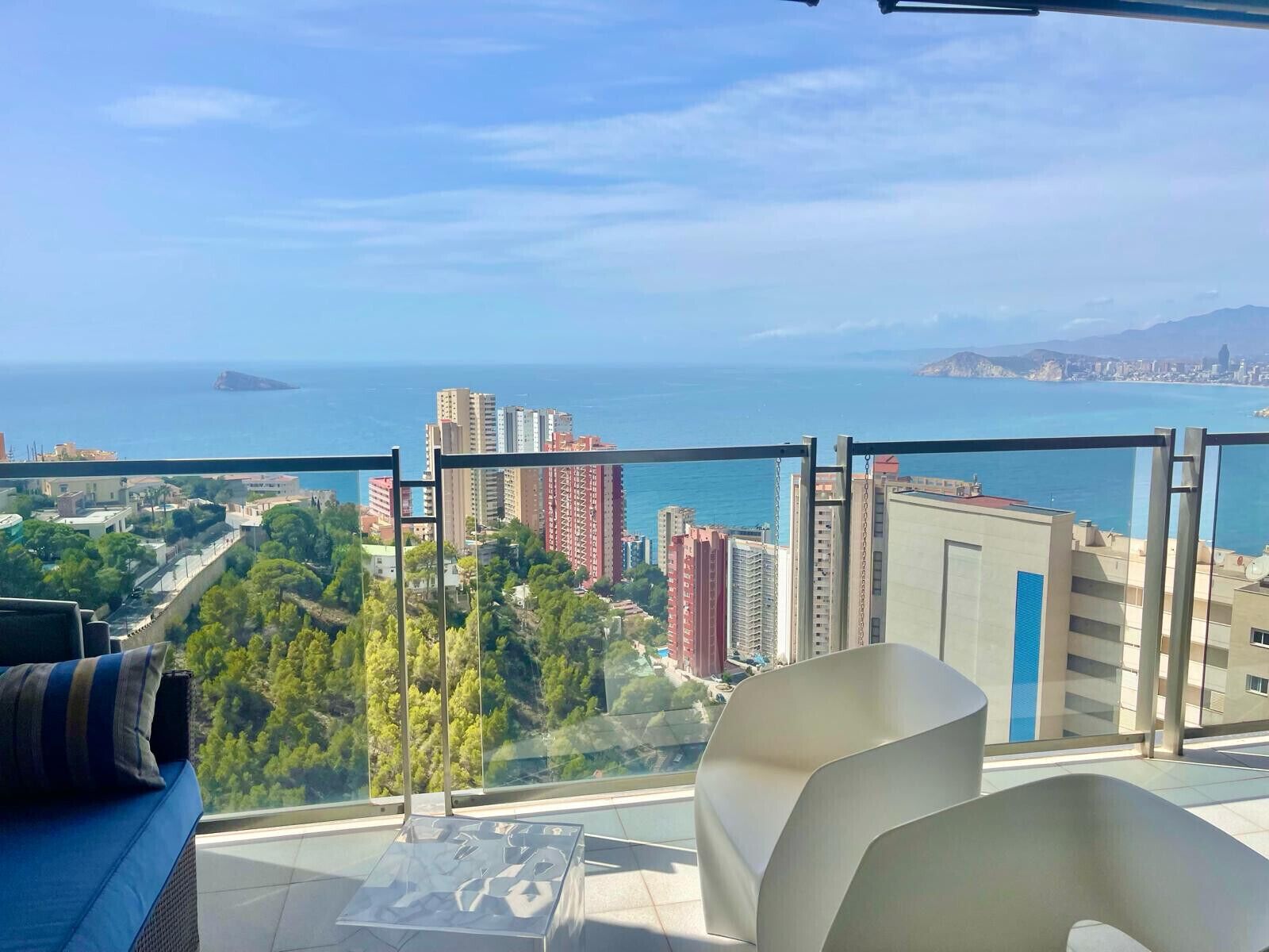Un balcon offrant une vue dégagée sur la mer et le paysage urbain.