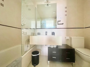 A modern bathroom with a glass shower enclosure, a white sink, a black vanity, and a toilet. - MIRADOR DEL MEDITERRANEO N172 (Benidorm)