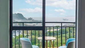 Un balcón con vistas a la costa, que incluye un puente y barcos.