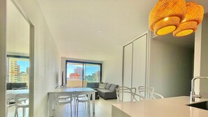 A modern apartment with a dining area, a sofa, and a kitchen counter. - LUXURY BENIDORM BEACH PONIENTE N107 (Benidorm)