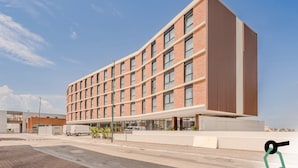 A modern hotel with a brick facade, large windows, and a flat roof. - Hotiday Venezia Tronchetto (Venice)