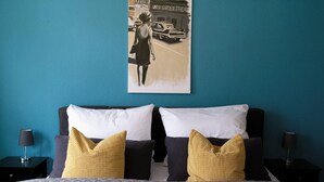 Ein Hotelzimmer mit einem Bett, zwei Nachttischen, einer Lampe und einem Poster an der Wand.