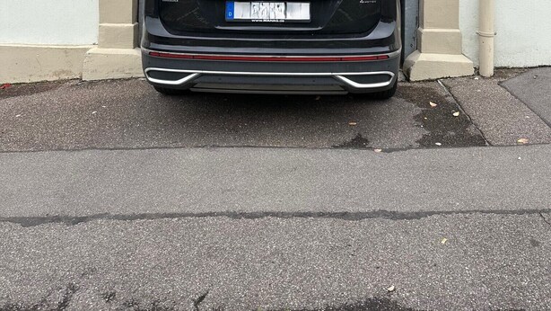 Ein schwarzer Volkswagen Tiguan vor einer Garage.