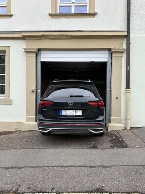 Un Volkswagen Tiguan negro estacionado frente a un garaje.