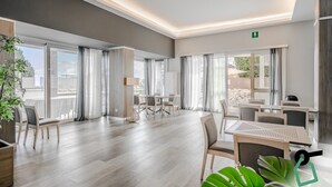 Ein geräumiges Hotelzimmer mit großen Fenstern, einem Balkon und einer modernen Inneneinrichtung.