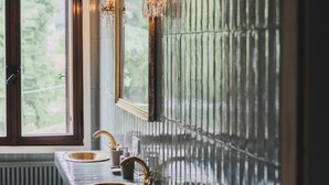 A bathroom with a large mirror, two sinks, and a towel rack.