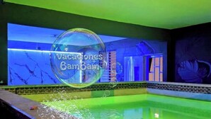 Une piscine décorée d’une grande structure en forme de bulle et sur laquelle on peut lire le texte : « Vacaciones Bambam ».