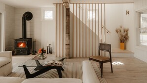 Ein modernes Wohnzimmer mit Kamin, einer Treppe und einem großen Fenster.