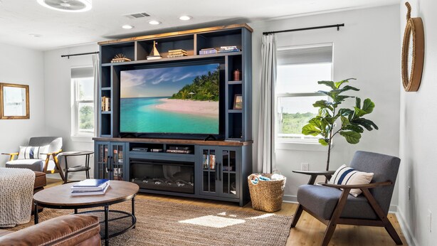 Una sala de estar con un televisor de pantalla plana grande, una zona de estar acogedora y vistas al exterior.