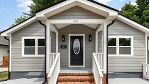 A two-story house with a front porch, a black front door, and the number 621 on the front. - Boho 5BR Modern Villa•Hot Tub•Grill•Patio•Backyard (Raleigh)