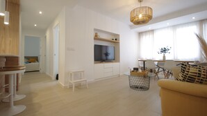 A modern living room with a TV, seating area, and a dining table. - 30 - Livingtarifa El Poniente (Tarifa)