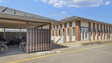 A building with a covered parking area and a brick facade.
