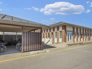 A building with a covered parking area and a brick facade. - Inviting Holiday Home in Fano (Fano)