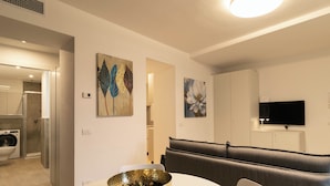 A modern living room with a round table, a sofa, and artwork on the walls.