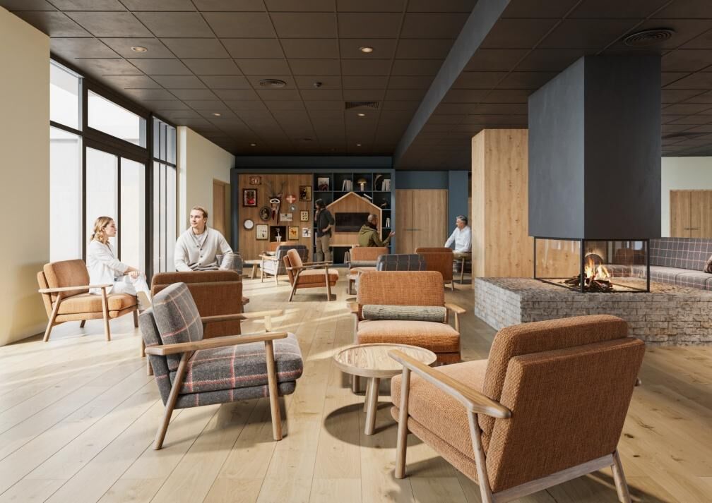 A spacious lobby with multiple seating areas, a fireplace, and a wall adorned with various artworks.