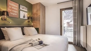 Habitación de hotel con una cama grande, vistas al exterior y decoración en las paredes.