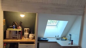 A compact kitchen with a built-in microwave, coffee maker, and a small window for natural light. - Chambre en Brière with jacuzzi near Guérande (Saint-Lyphard)