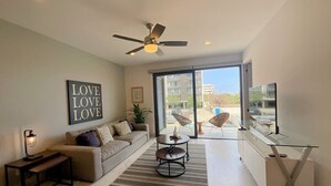 A modern living room with a sofa, coffee table, and TV stand.