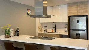 A modern kitchen with a central island, stainless steel appliances, and bar stools.