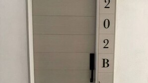 A door with a numeric keypad and a mail slot, indicating a secure entry point.
