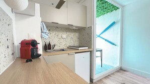 A compact kitchen with a built-in oven, a sink, and a small refrigerator.