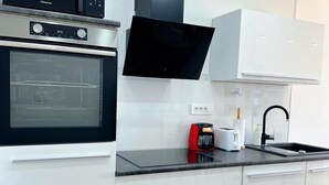A modern kitchen with a built-in oven, a coffee maker, and a sink. - Sea View Apartment Rijeka-free Parking-6 People (Rijeka)
