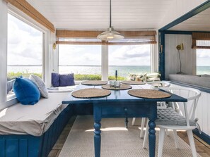 A dining area with a table, chairs, and a view of the sea. - 4 Person Holiday Home in Martofte (Martofte)