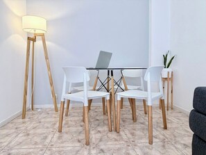 Een moderne eethoek met een tafel, stoelen en een laptop.