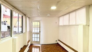 A hallway with a wooden floor, a door, and windows. - Central Apartment for 4 (Buenos Aires)