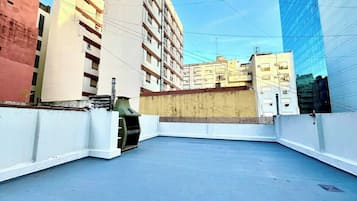 Terraço no telhado com vista para os edifícios ao redor.