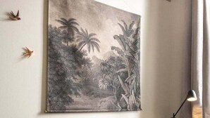 A room with a grey sofa, a white table, and a large wall-mounted artwork depicting a tropical scene. - Lovely cozy studio - Pentes of Croix Rousse (Lyon)