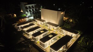 A modern building with multiple connected units, each with a flat roof and large windows, surrounded by greenery. - Sunny Pavilion (Thoddoo)