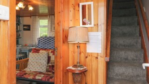 A wooden interior with a staircase, a lamp, and a framed picture on the wall. - Lehanmore House (Garinish)