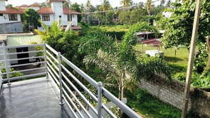 A residential area with houses, a garden, and a metal railing. - Tropical Suites (Negombo)