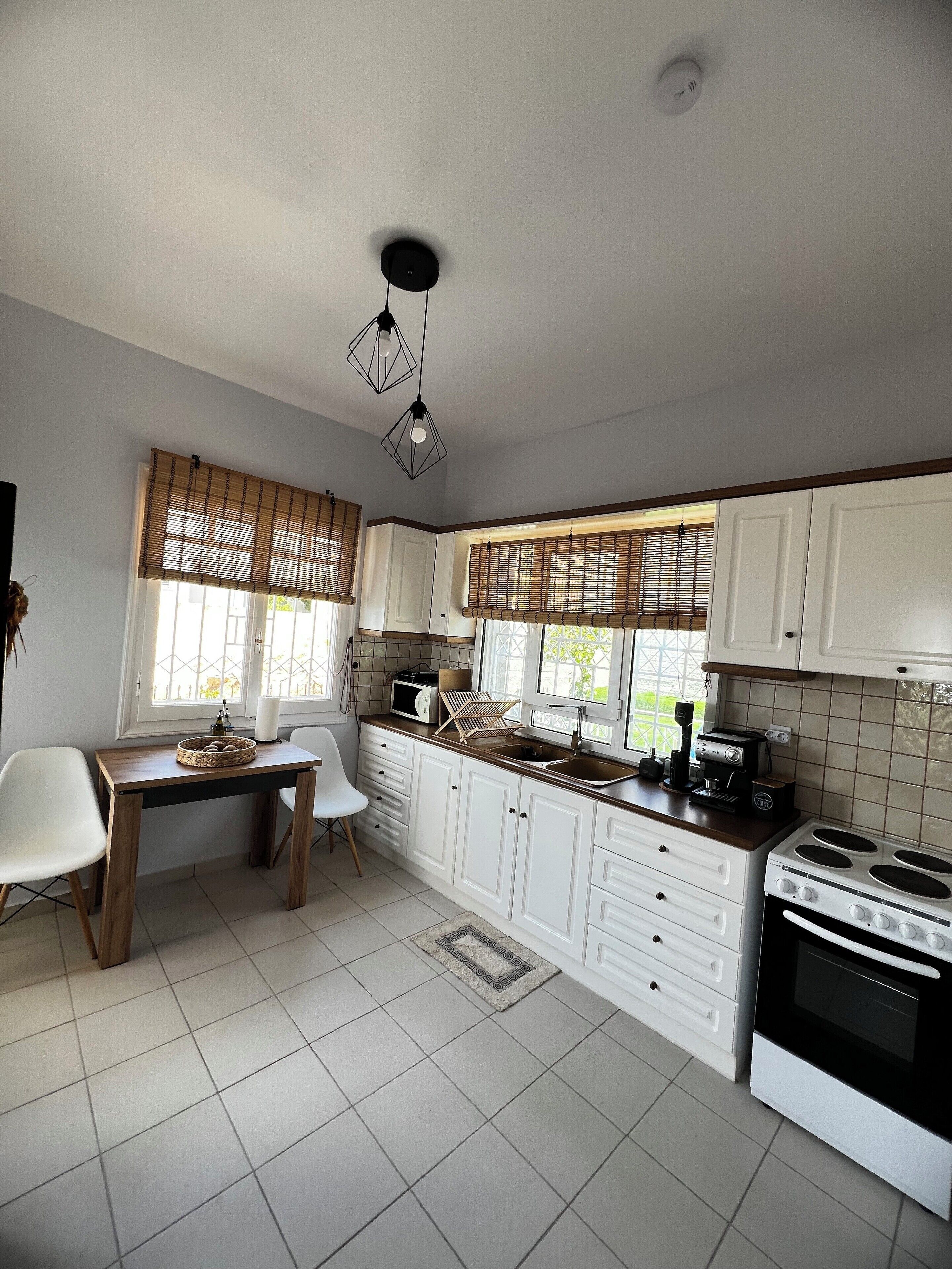 A kitchen with white cabinets, a wooden table, and a stove.