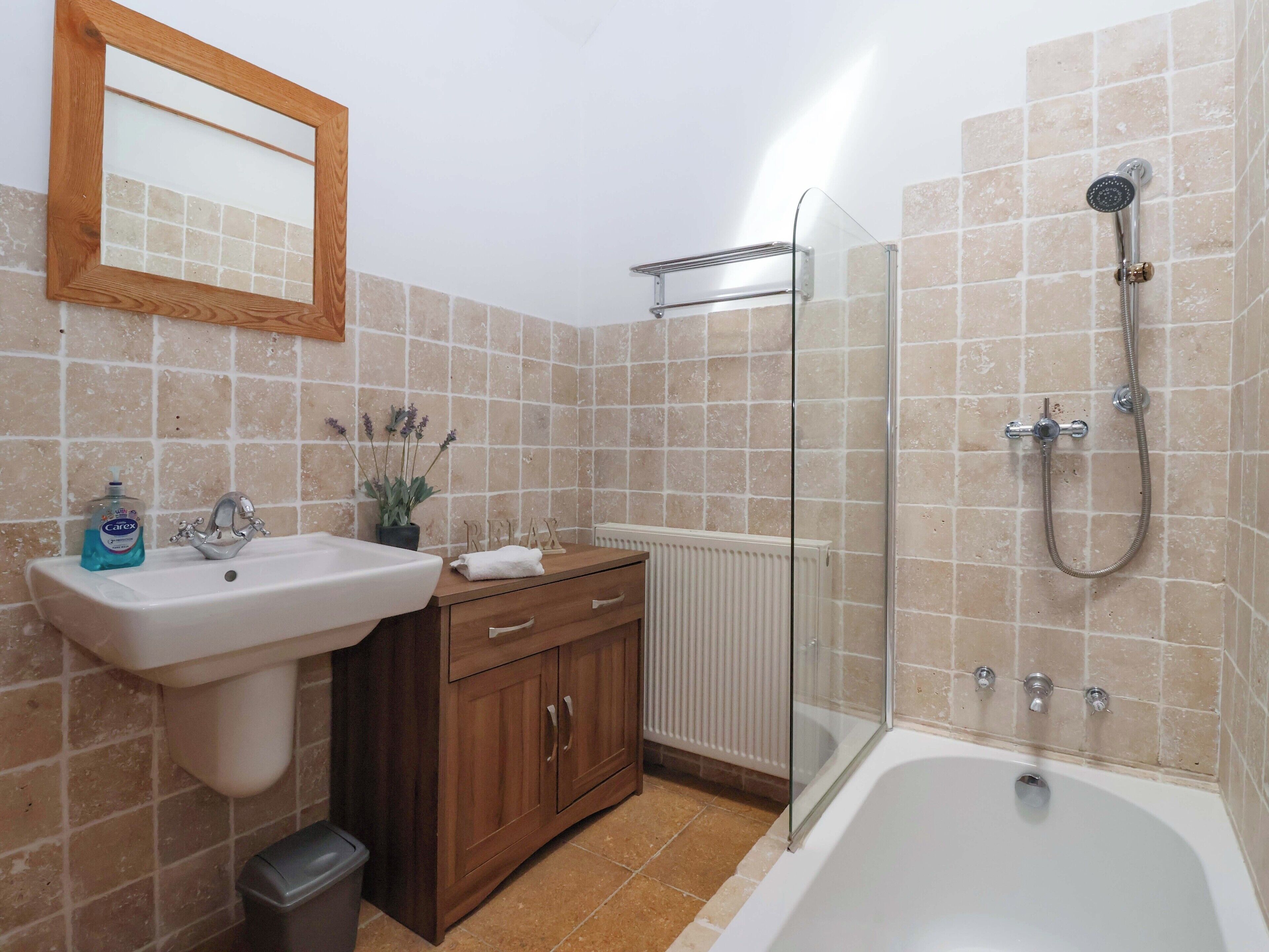 Une salle de bain équipée d’un lavabo, d’un meuble-lavabo et d’une zone douche.