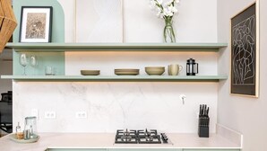 Une cuisine équipée d’une cuisinière à gaz, d’une machine à café et d’un bloc à couteaux.
