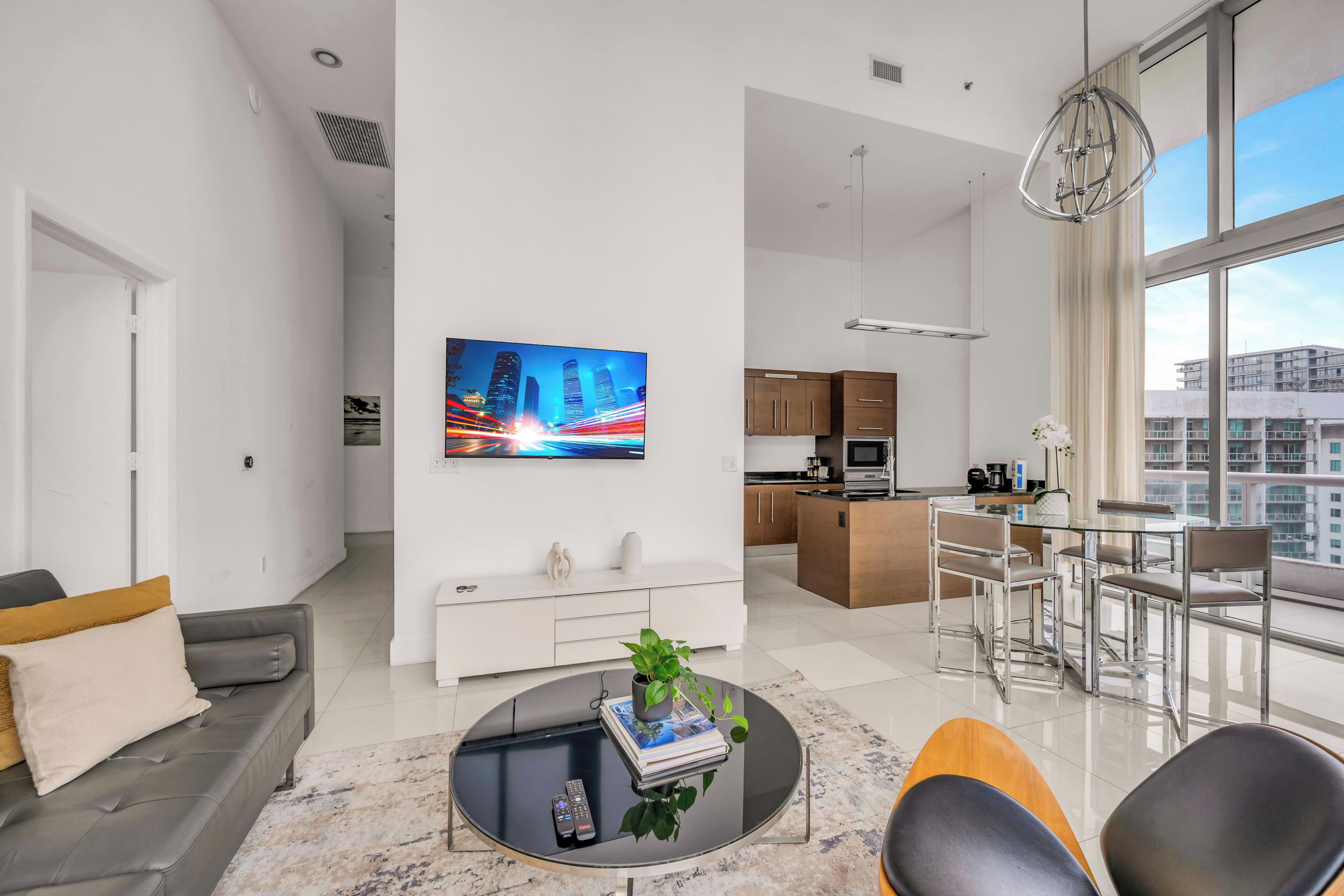 A modern living room with a sofa, coffee table, and a TV mounted on the wall.