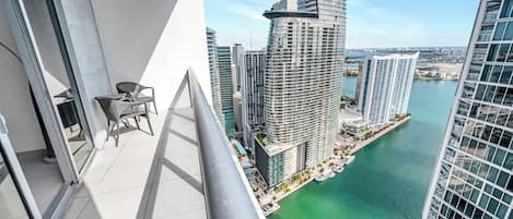 A high-rise building with a view of a body of water and other buildings.