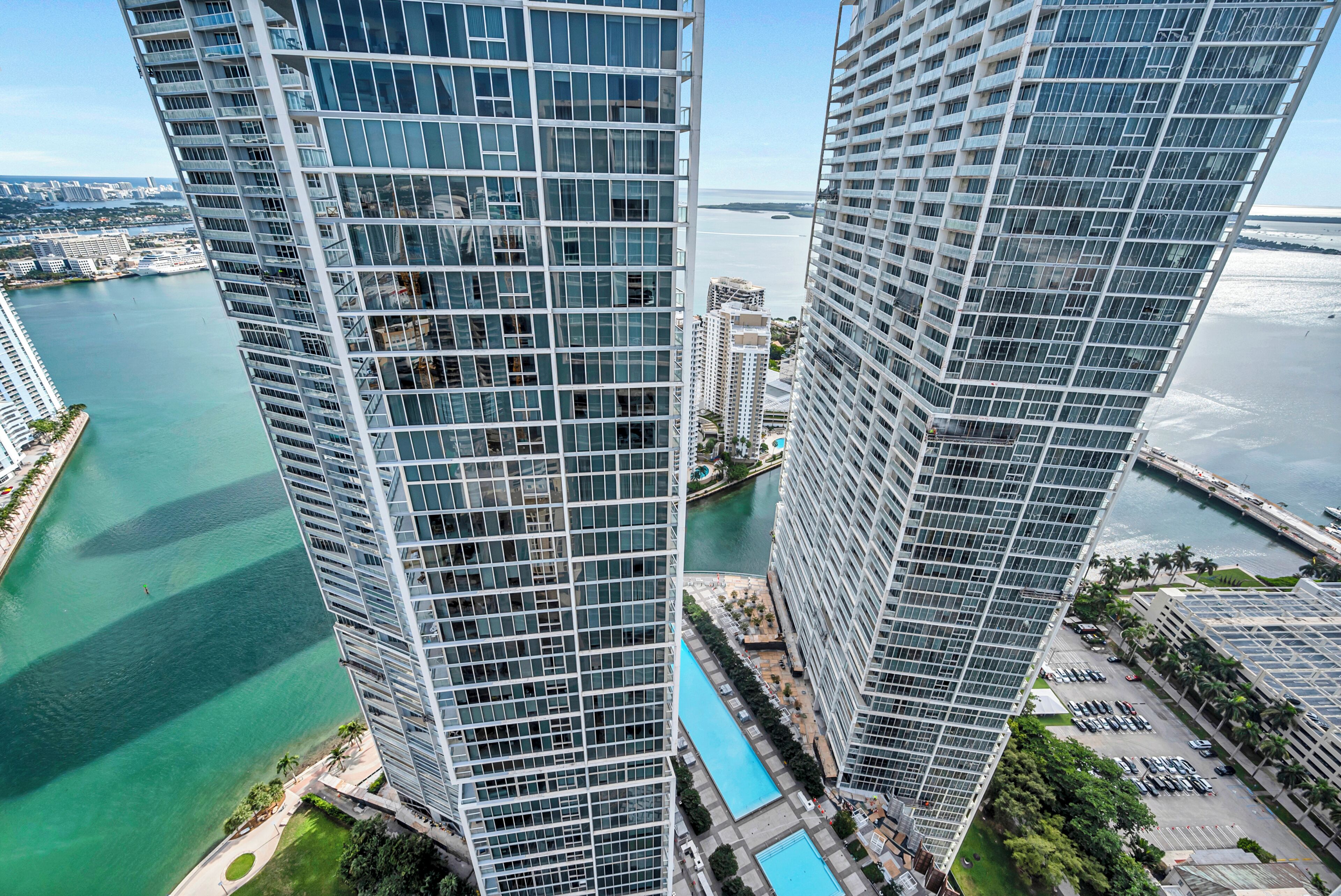 Un edificio alto con vista a una masa de agua y otros edificios.