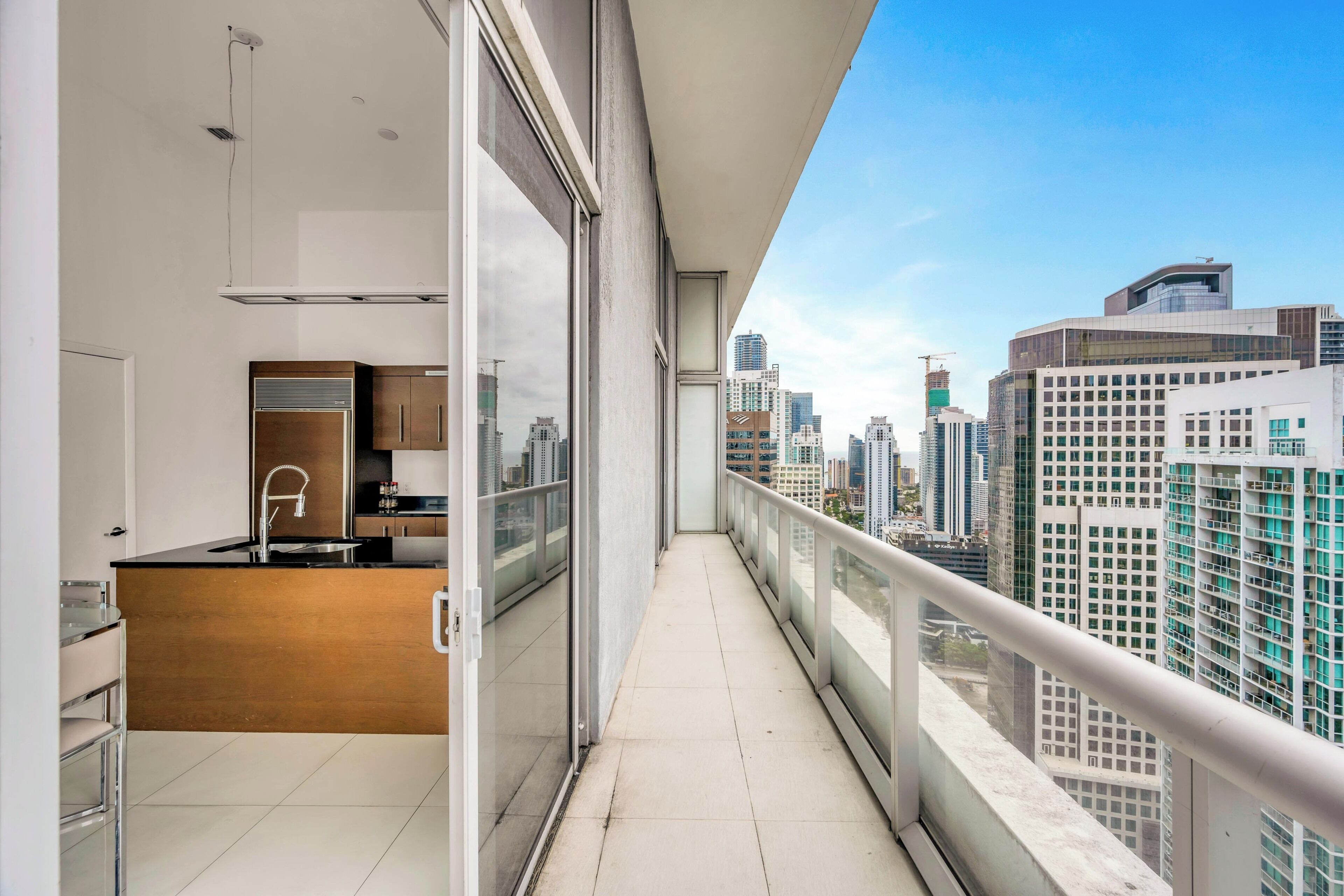 Een modern appartement met een keuken, een balkon met uitzicht op de stad en een groot raam.