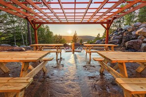 A wooden picnic area with benches and a pergola structure.