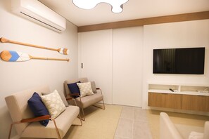 A modern living room with two sofas, a flat-screen TV, and a wooden cabinet. - Studio Shopping OKA Floripa - SOK108 (Florianopolis)